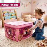 A young girl in denim overalls kneels on a rug next to a large pink carriage storage box