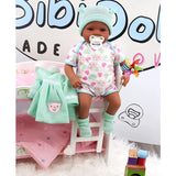 "Babydoll's pink dress and blue blanket, sitting on a pink doll bed with wooden blocks." - UKBuyZone