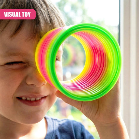 A child holding a colorful, spiral-shaped toy with a hole in the center, made of flexible plastic. The toy has a bright, vibrant color scheme with pink, green, and yellow stripes. - UKBuyZone