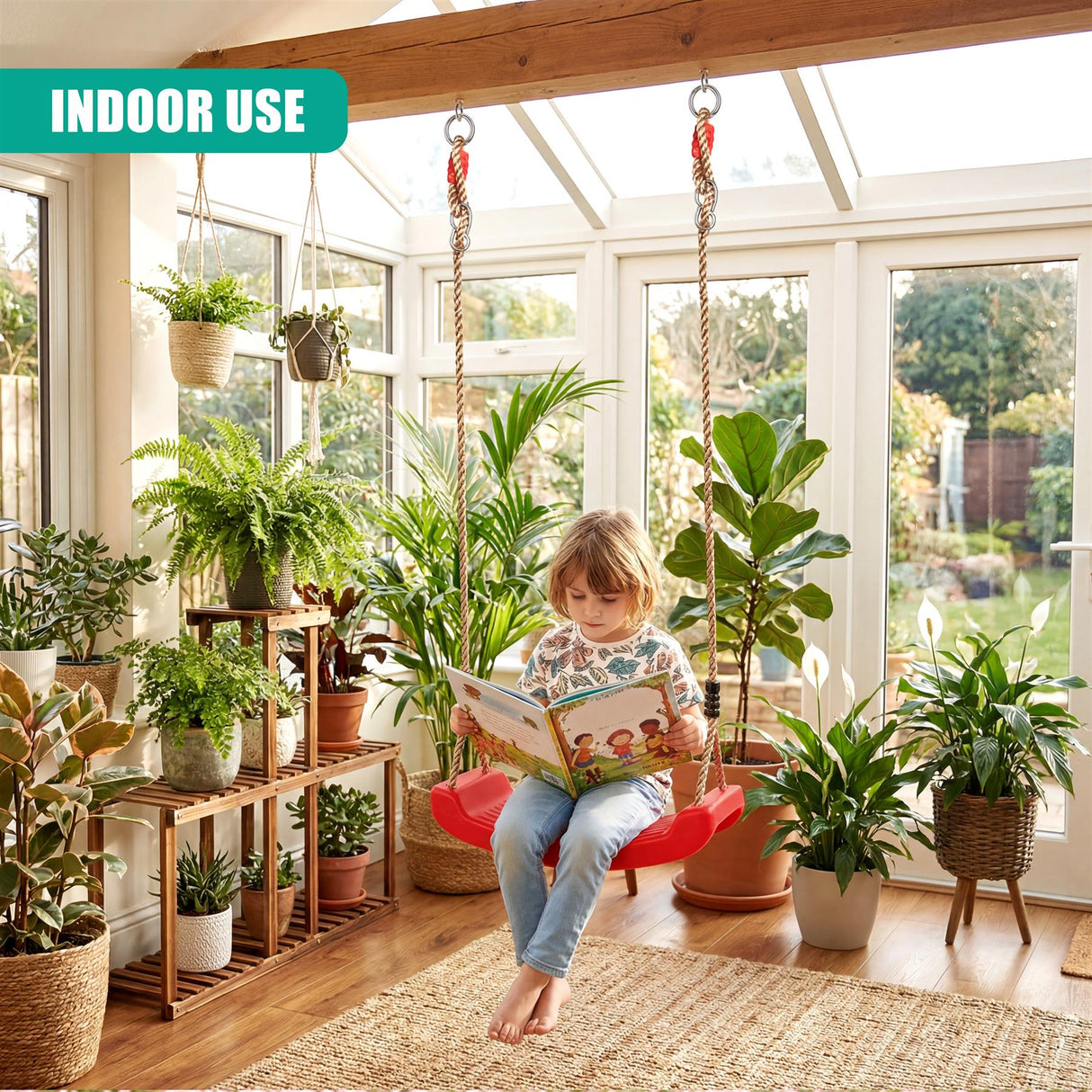 A child reads on a red swing seat indoors, surrounded by potted tropical plants and shelving.