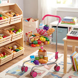 Metal toy shopping cart loaded with play food and accessories sitting on a rug.