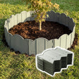 Scalloped, gray garden edging fence installed around a planted area, with stacked sections visible on the ground.