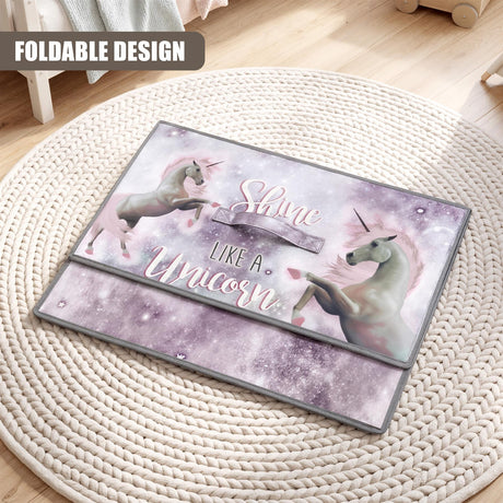 The Magic Toy Shop Unicorns Large Storage Box is folded on a round woven mat, showing its unicorn design and 'shine like a
