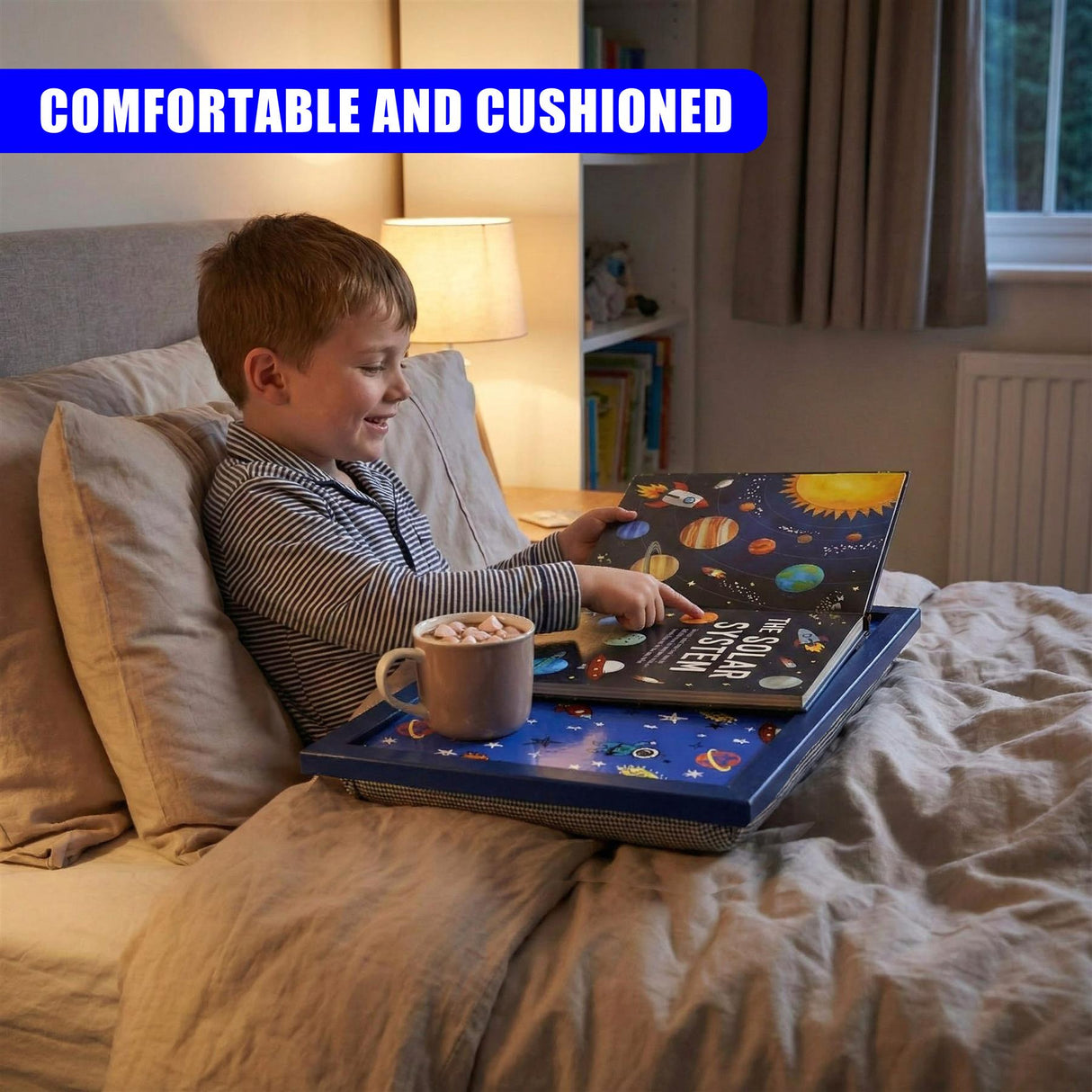 A boy reads from a solar system lap tray while sitting on a bed.