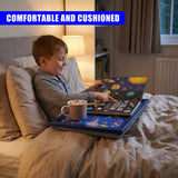 A boy reads from a solar system lap tray while sitting on a bed.