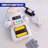 A white battery eliminator kit for AA and AAA batteries, shown with its power adapter and cable laid out on a light surface