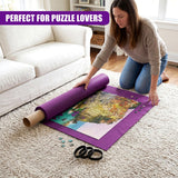 Woman placing a rolled puzzle mat and small black puzzle pieces on a cream carpet.