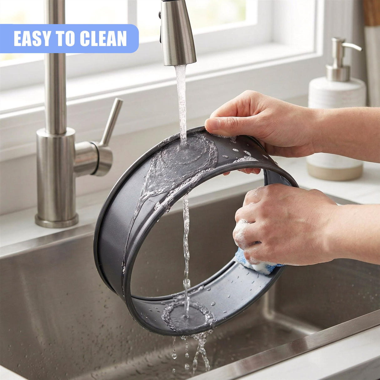 A used metal cake tin is rinsed with water in a stainless steel kitchen sink.