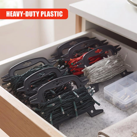 Black Christmas light reel storage holding various fairy lights and a small box of bulbs inside an open drawer
