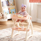 Doll high chair for play features a pink tray, bottles, and accompanying feeding accessories.