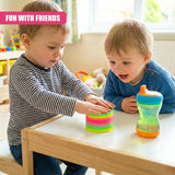 A child plays with a colorful, spiral-shaped toy on a table. The child's friend, also a child, sits nearby, holding a sippy cup. The room is filled with toys and toys are visible in the background. - UKBuyZone
