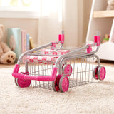 Pink metal toy shopping trolley with a doll seat rests on a cream carpet.