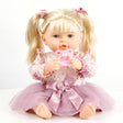 Blonde doll with pigtails, wearing a floral top and pink tulle skirt, holding a baby bottle.