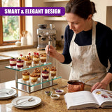 Mini desserts are arranged on a multi-tiered glass stand on a kitchen countertop.