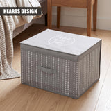 A large gray fabric storage box with a heart pattern and "Neat and Tidy" on the lid, placed on a wooden floor next to a bed