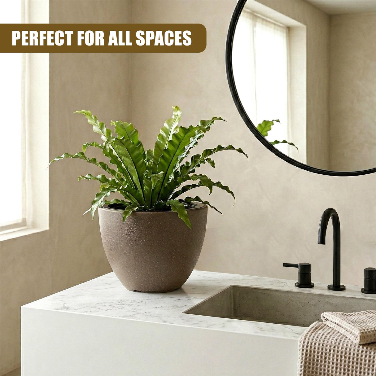 Potted green plant in a matte, neutral-colored oval pot on a white marble bathroom counter.