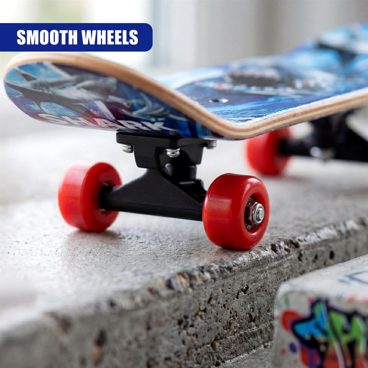 Blue skateboard deck with red wheels rests on a rough gray concrete surface.