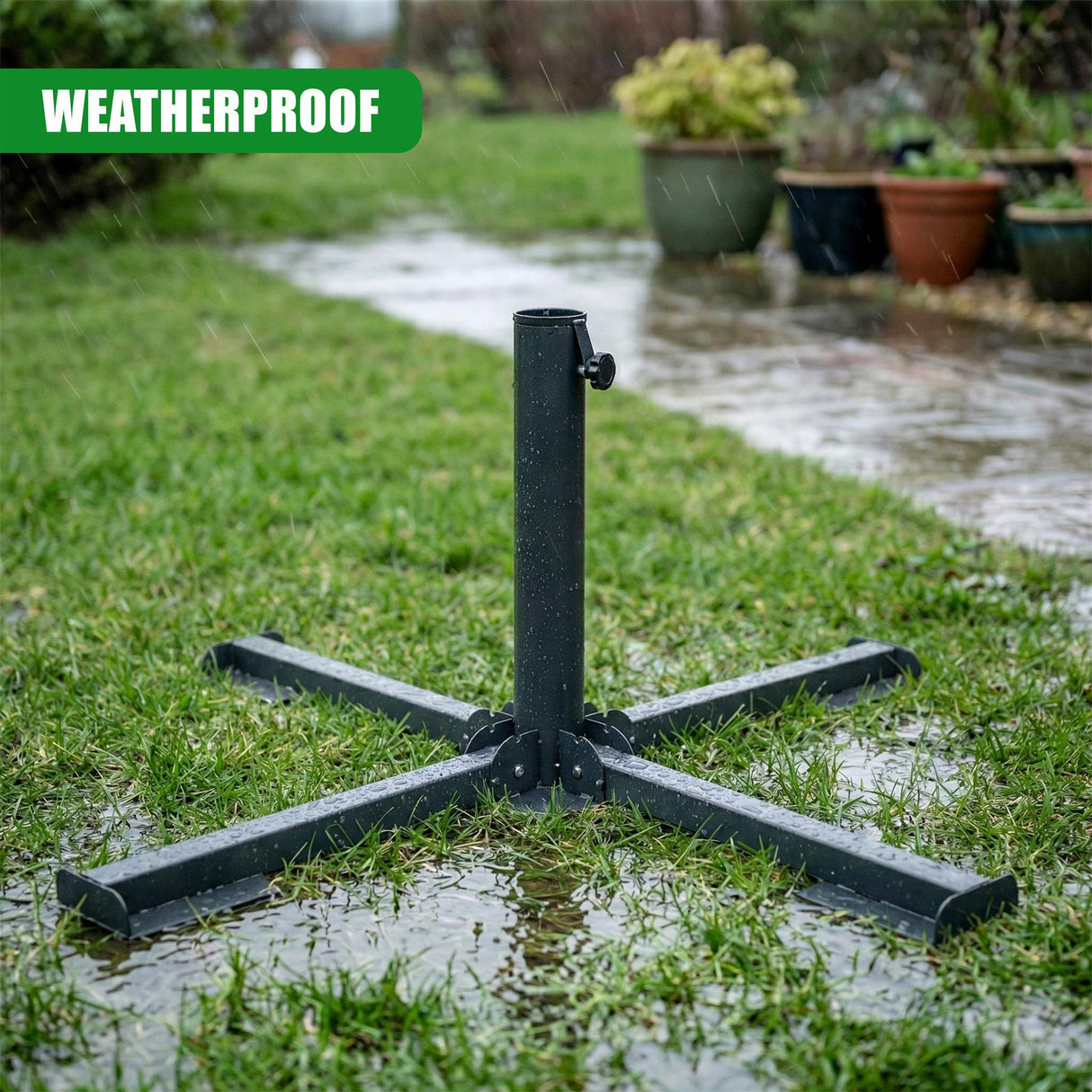 Black metal patio base with a folded frame sits on wet grass outdoors.