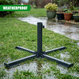Black metal patio base with a folded frame sits on wet grass outdoors.