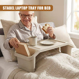 A person enjoying a meal in bed with a tray table. This advertisement features an elderly gentleman enjoying a sandwich and drink while resting comfortably on a bed. The tray table has storage compartments underneath the tray, providing additional convenience for the user. It is made from sturdy material and has wheels for easy mobility around the room. - UKBuyZone