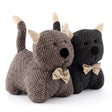 Three plush figures: a light brown dog, and two matching dark gray stuffed animals.
