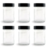 Set of six clear glass spice jars displayed with matching solid black screw-top lids.