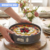 A round springform cake tin holds a baked tart topped with fresh berries and yellow fruit slices.