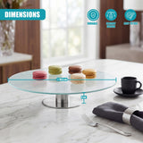 Circular glass cake stand with metal base, displaying several macarons on a white marble counter.