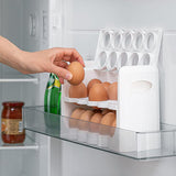 A clear plastic tray with two dozen eggs on the shelves, inside an open refrigerator.