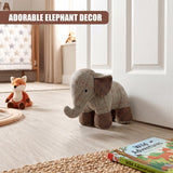 A plaid fabric elephant door stopper rests on a wooden floor near white paneling.