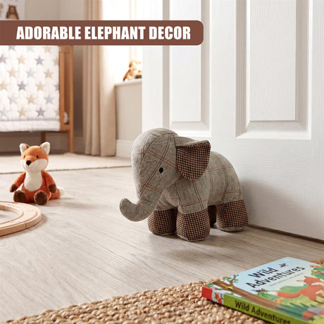 A plaid fabric elephant door stopper rests on a wooden floor near white paneling.
