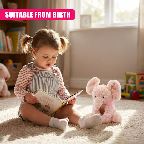 A young girl sits on a carpeted floor, surrounded by toys and books. She holds a book in her hands, while a pink plush elephant sits beside her. The room is filled with natural light, illuminating the child's face and the toys. - UKBuyZone