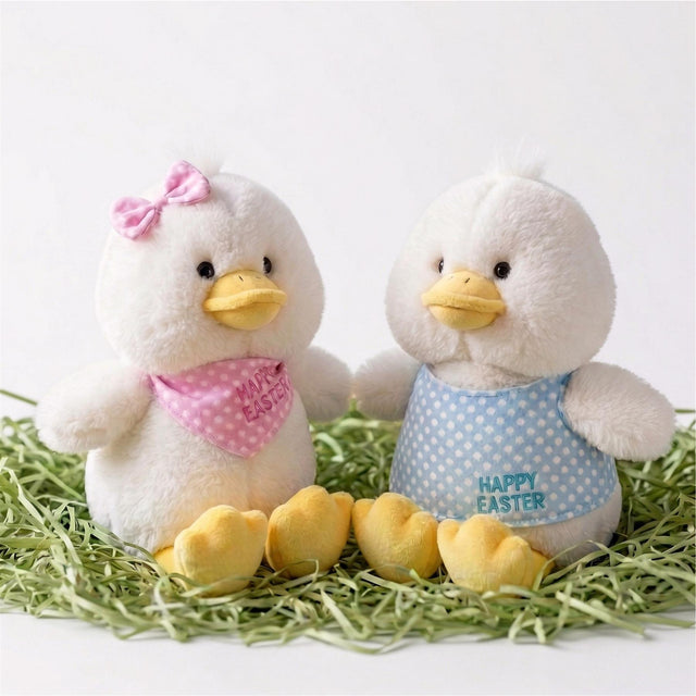 Two white plush chicks and yellow decorative eggs rest in a bed of straw.