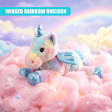 Plush unicorn toy with rainbow accents and wings rests on fluffy pink cloud-like material.
