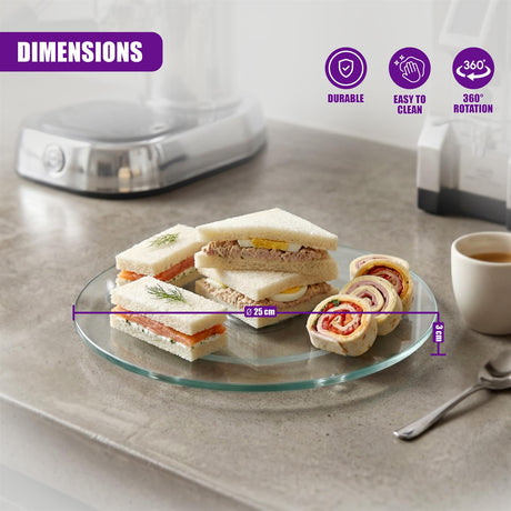 Glass lazy susan turntable displaying cut sandwiches and rolls on a counter.