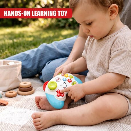A baby wearing a beige top sits on a blanket outdoors, playing with a Game Controller Toy from The Magic Toy Shop