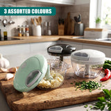 Three manual food choppers rest on a wooden board next to fresh chopped ingredients.