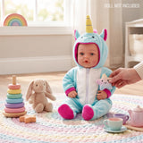 Reborn doll in unicorn outfit sits near a bunny toy, teacups, and stacking ring toys.