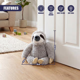 The plush sloth door stopper is gray and sits against a white door frame.