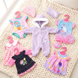 Set of doll clothes featuring pink, blue, purple, and floral patterns, including rompers, dresses, and a hooded sleeper.