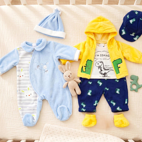 Doll clothing set laid out, featuring a blue romper, yellow hoodie, and dark blue pants.