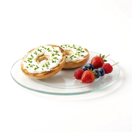 Three topped bagels, fresh berries, and cream cheese are displayed on a clear glass turntable.