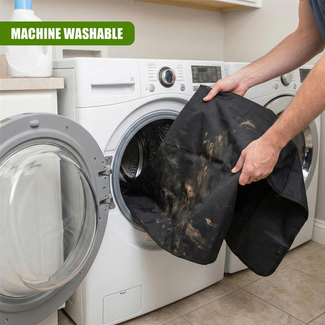Black, soiled pet car seat cover is being washed in a white washing machine.