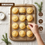 A rectangular baking tray filled with round, golden biscuits, with a hand reaching into the product.