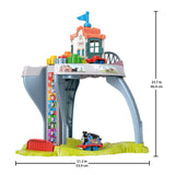 Wooden playset featuring a station structure, toy train tracks, and plastic locomotive toys.