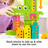 Child uses a green alligator math toy with stacked blocks to count and calculate sums.