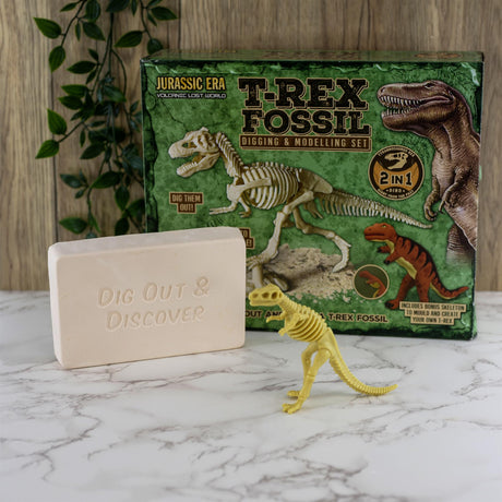 The kit box, a beige block, and a yellow dinosaur figurine rest on a white marble surface.