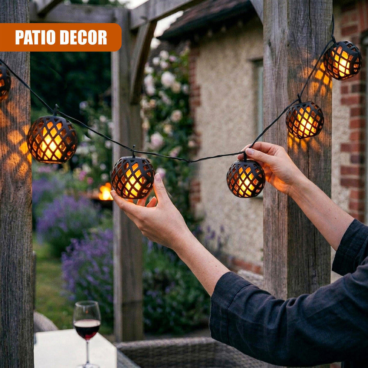 Hands hang rattan woven solar lights strung across a dark wooden patio structure.