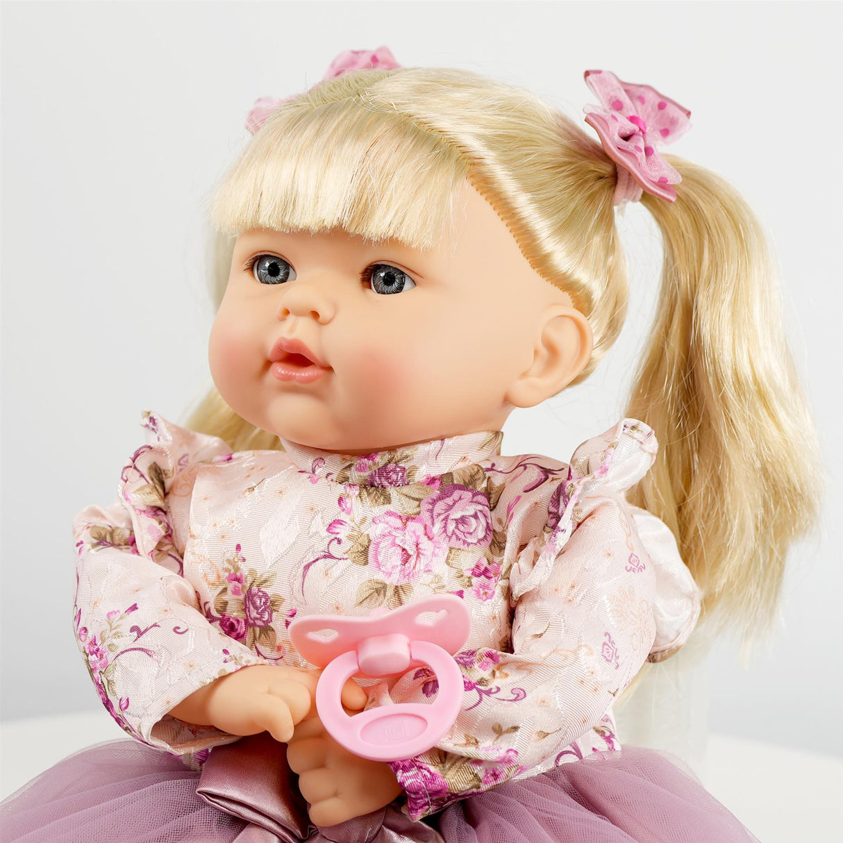 A doll with blonde hair, wearing a purple dress.