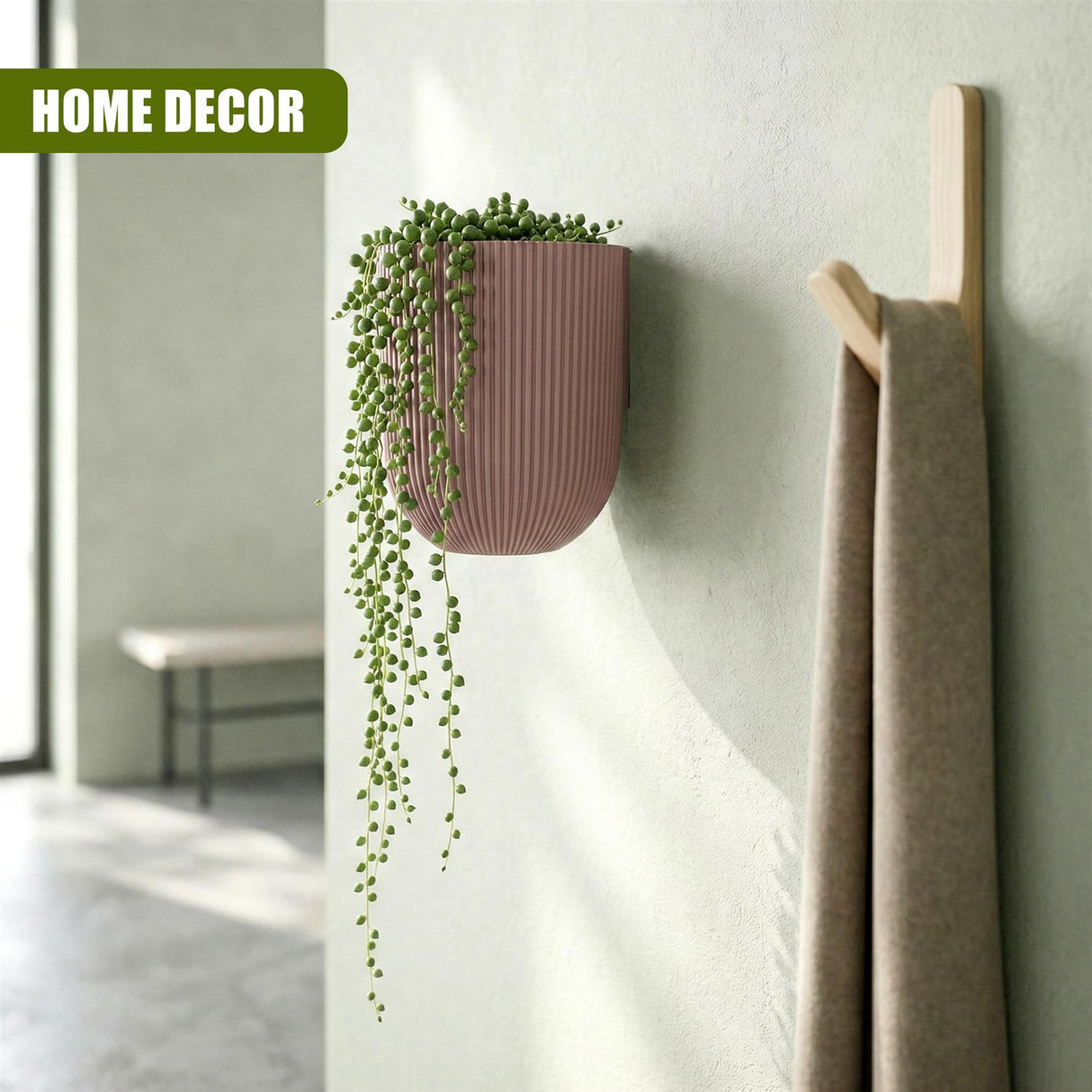 Wall decor featuring a coral planter with greenery next to a wooden towel ladder.